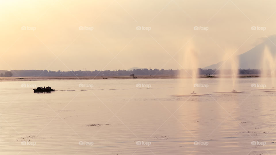 Amazing "Foara" also called a water show or water sprinkler Natural Fountains in Shalimar Bagh, Srinagar, Kashmir on banks of Dal Lake, central channel with sunlight reflecting during sunset time.