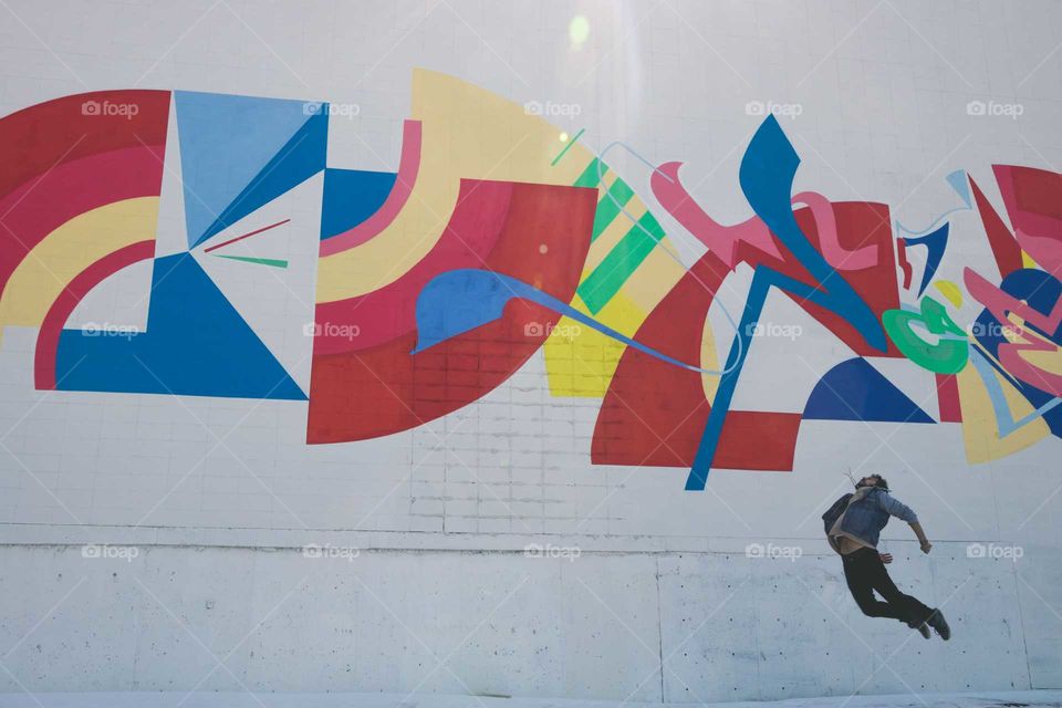 Male Jumping in front of Colourful Mural, Mid Winter, Sun Shining