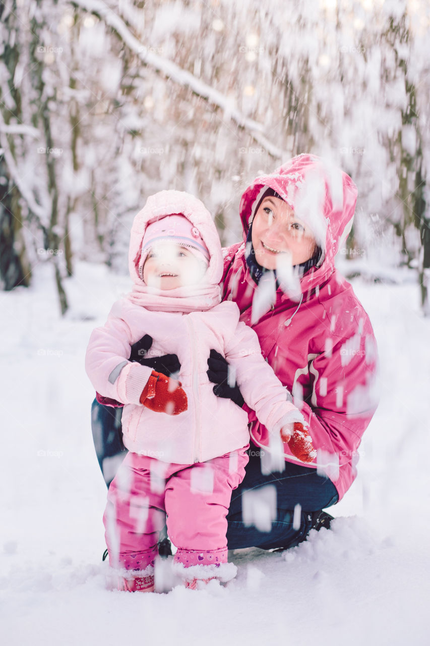 Mother spending time with her little daughter outdoors in the wintertime