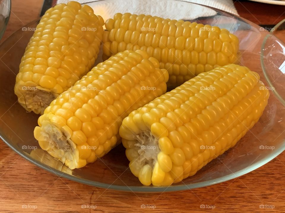 Sweet corn in a glass bowl with brown background. 