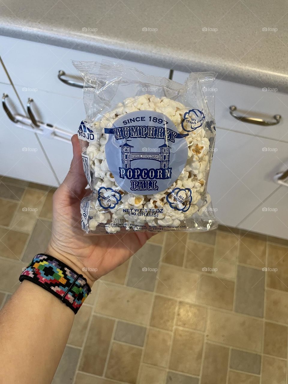 Woman’s hand holding a popcorn ball, celebrating the holidays with Popcorn Balls, woman holding popcorn ball