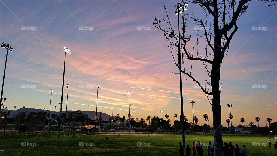 Spring Baseball.  Families gathering at the local ballpark to watch their children play and enjoy the mild spring evening!