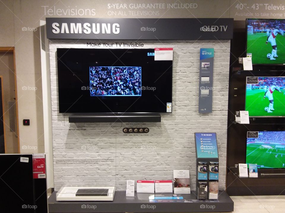 Samsung QLED ambient mode television wall mounted with soundbar and one connect box