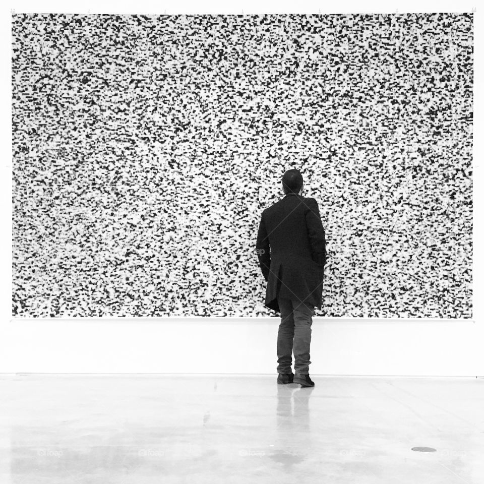 Man watching painted wall in exhibition