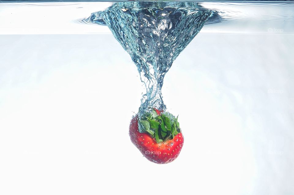 Strawberry splash in clear water