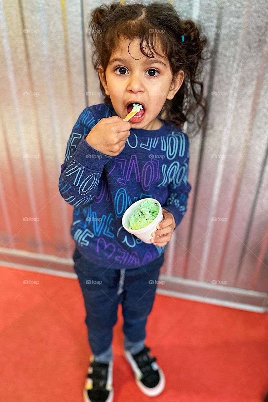 Little girl eats ice cream, eating ice cream out of a bowl, toddler girl eats mint chocolate chip ice cream, open mouth eating ice cream, treats in the summer 