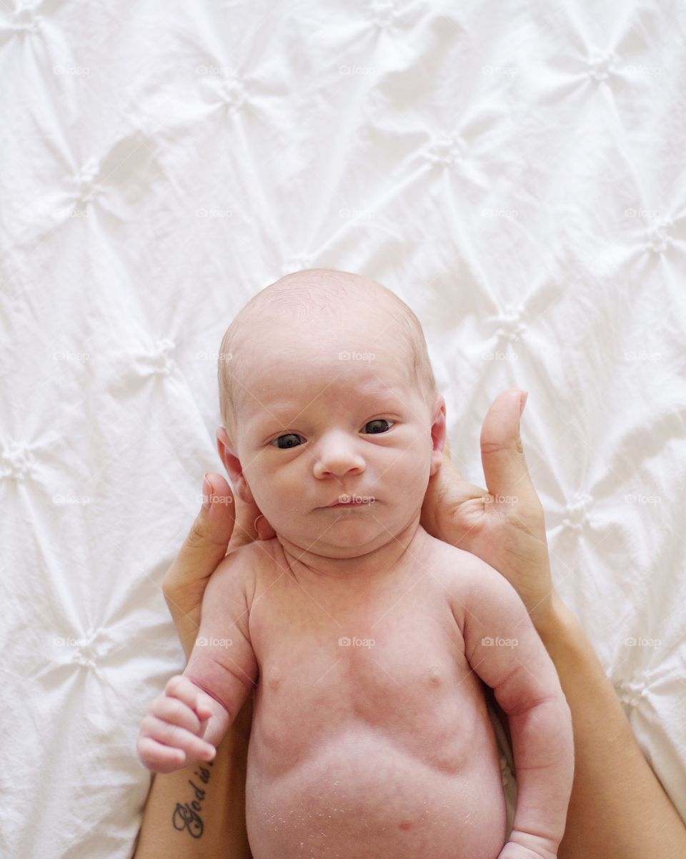 Newborn held by mother flatlay