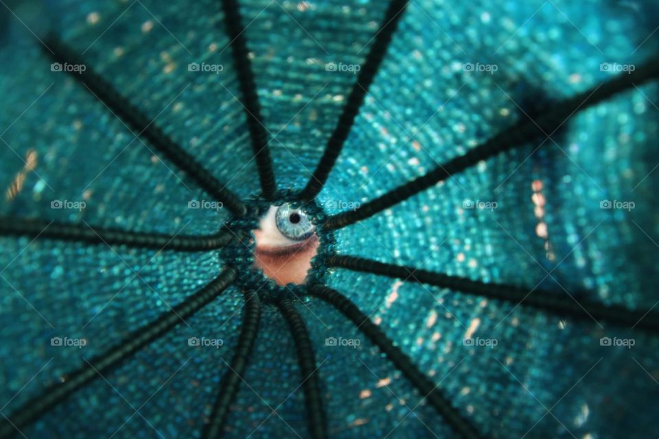 Close-up of a blue eye looking through turquoise beads