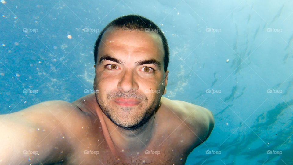 young man diving and swimming underwater