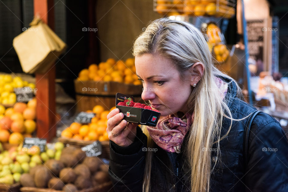 Woman smelling fresh strawberries in market