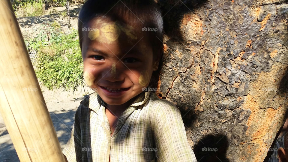 Kid with Tanaka herb on face that people in Myanmar always put it on like their signature