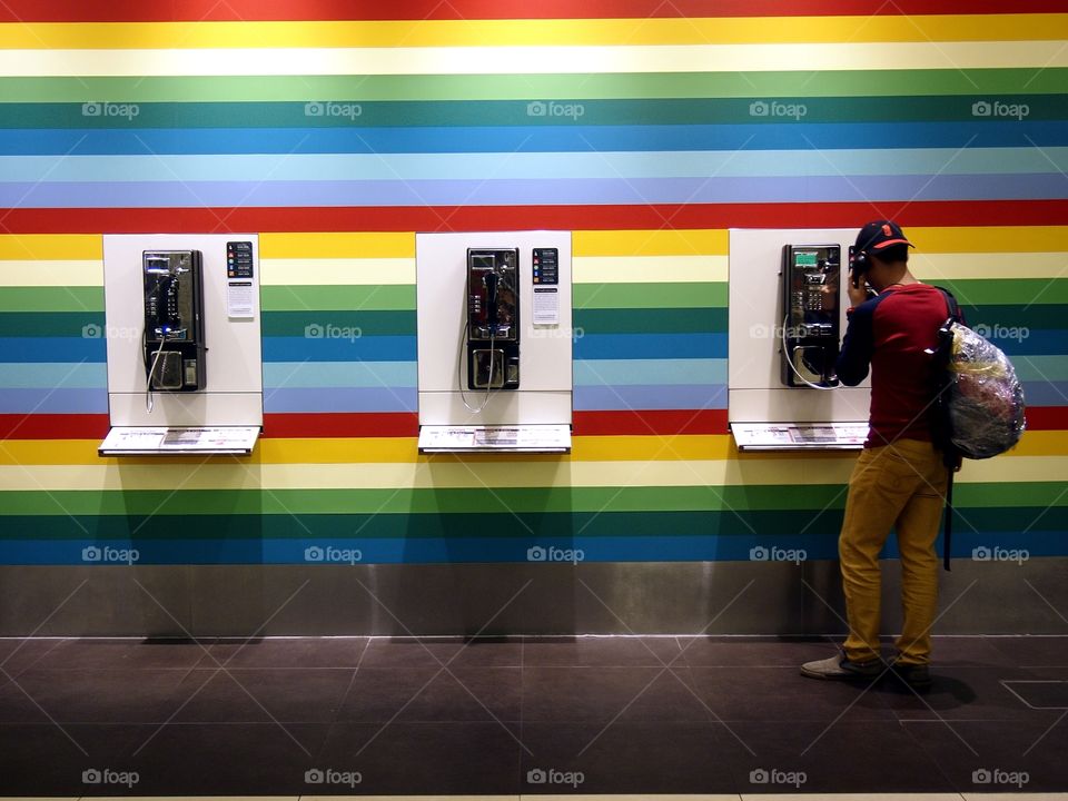 man using public pay phone in changi airport