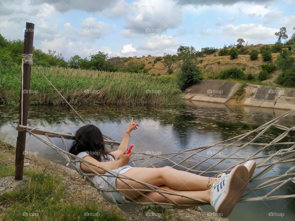 A girl in a hammock by the lake