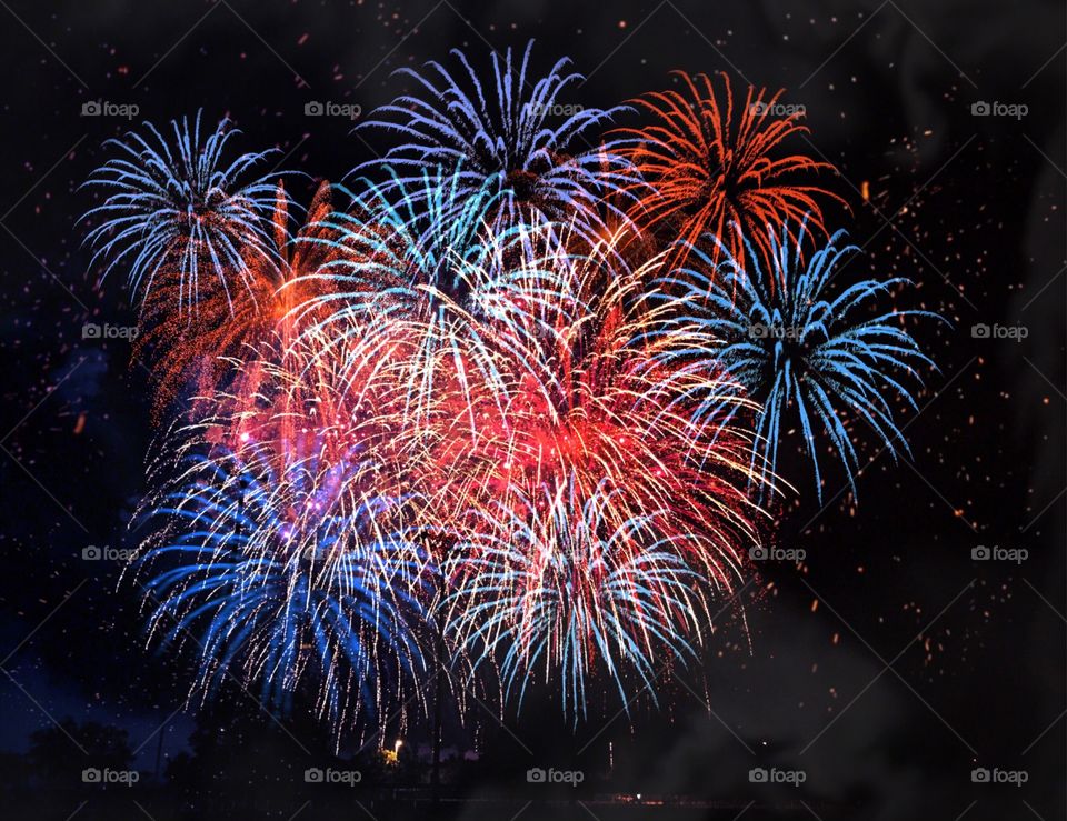 Red White and Blue patriotic fireworks light up the dark sky.