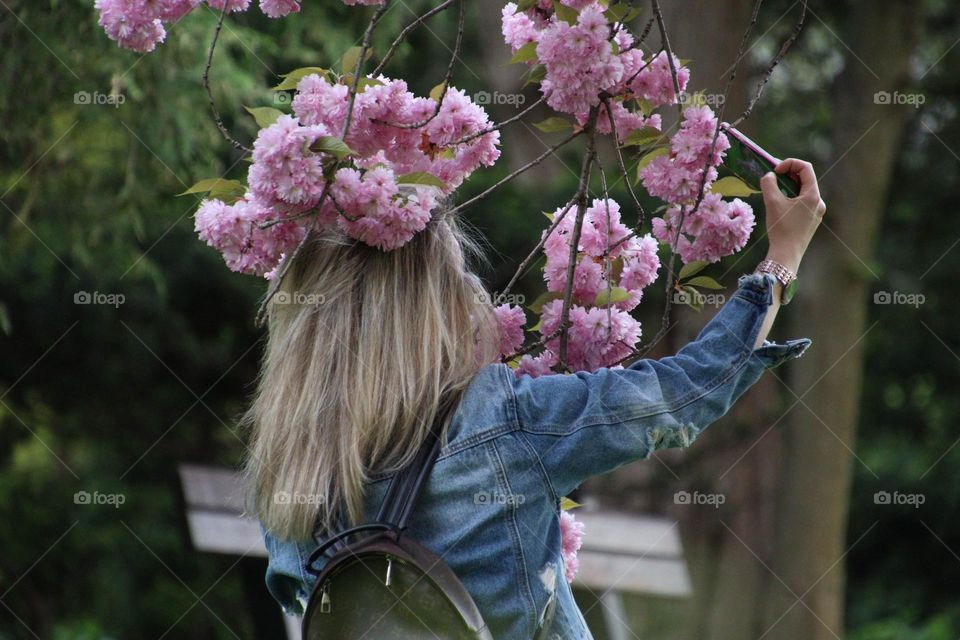 Woman is taking a selfie with apple tree bloom