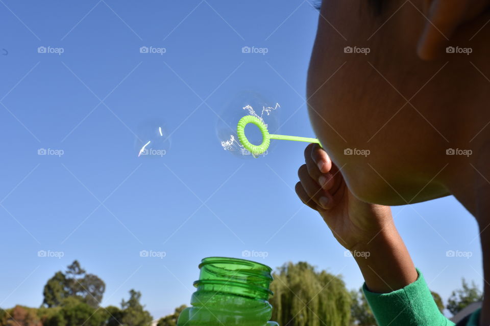 Kid playing with soap bubbles