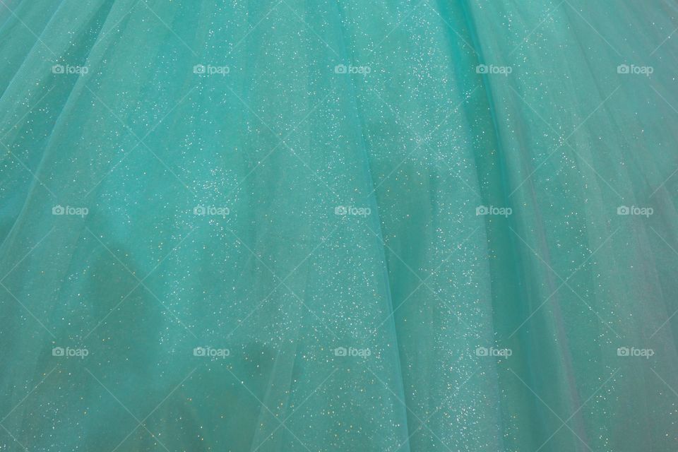 A closeup abstract of a kids formal aqua dress on display in a children's clothing store in San Miguel de Allende, Mexico