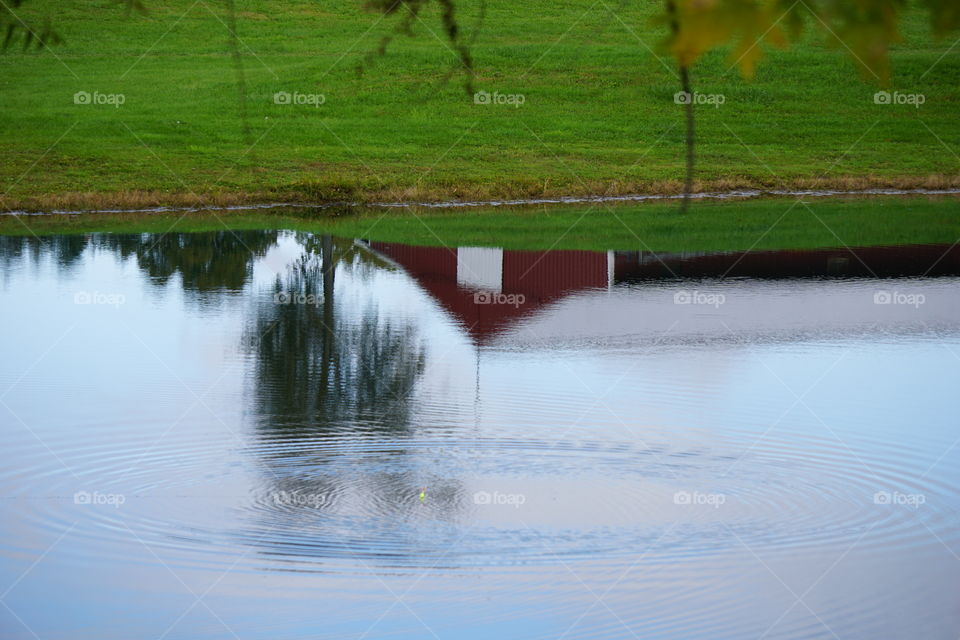 A rippling pond and a barn’s reflection. 