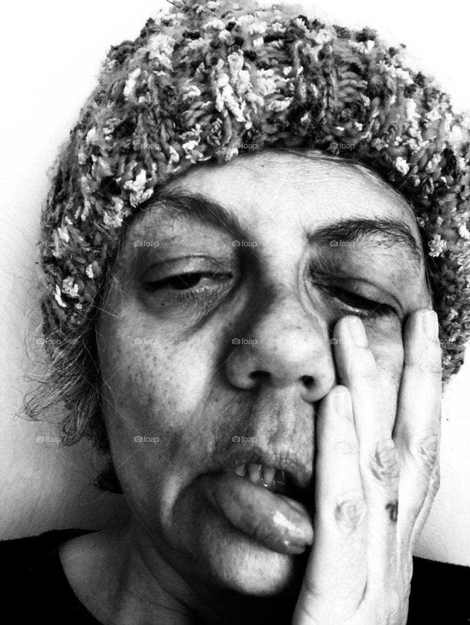 Woman in a wool hat shows her emotions for being stuck indoors during a particular cold winter weekend.