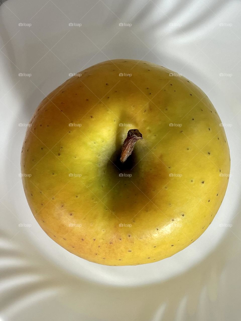 Round shape of an apple seen from above against white background 