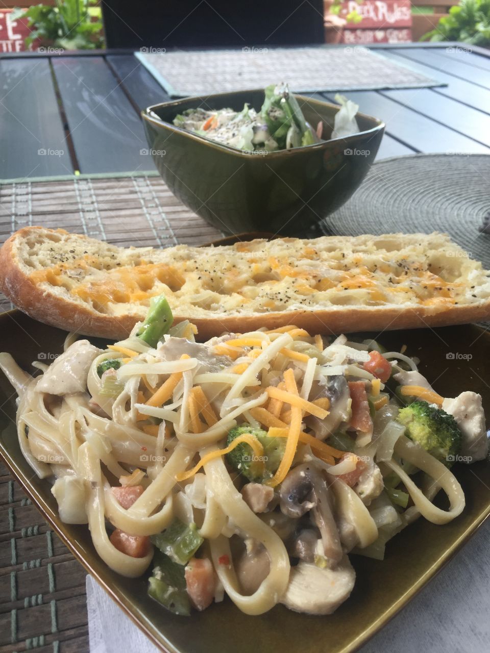 Vegetable chicken Alfredo with garlic bread and a salad
