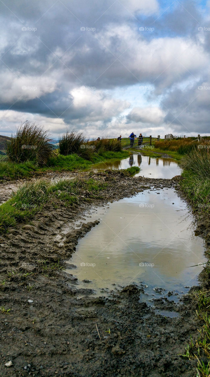 people reflected in a puddle, Wales, UK