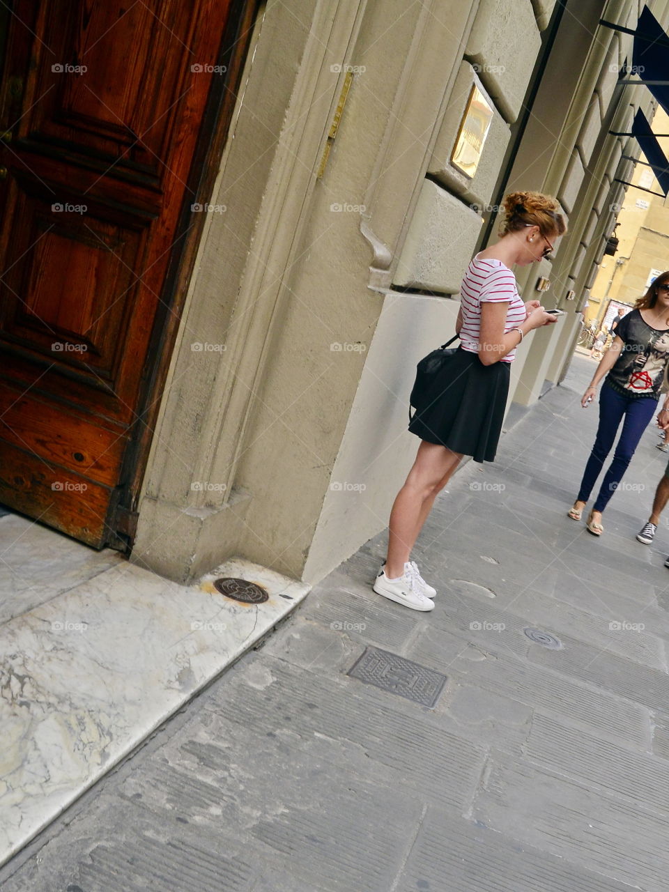 a girl waiting for a friend in the street