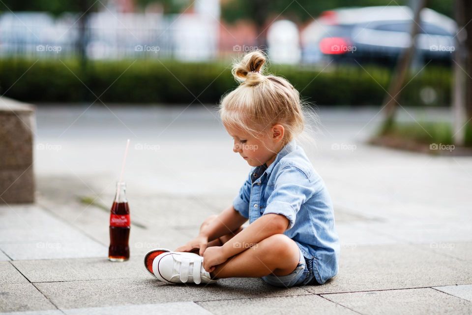 Little Caucasian girl singing on road at summer 