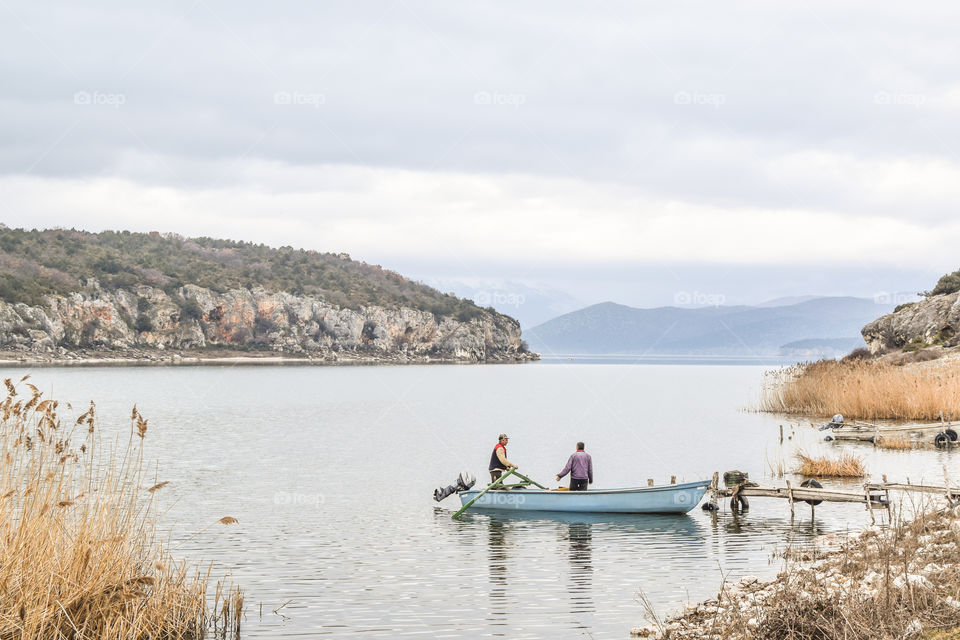 Two Fishermen With Their Boat Going For Fishing
