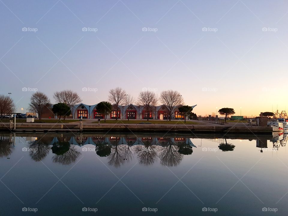 Reflection of house in lake at sunset