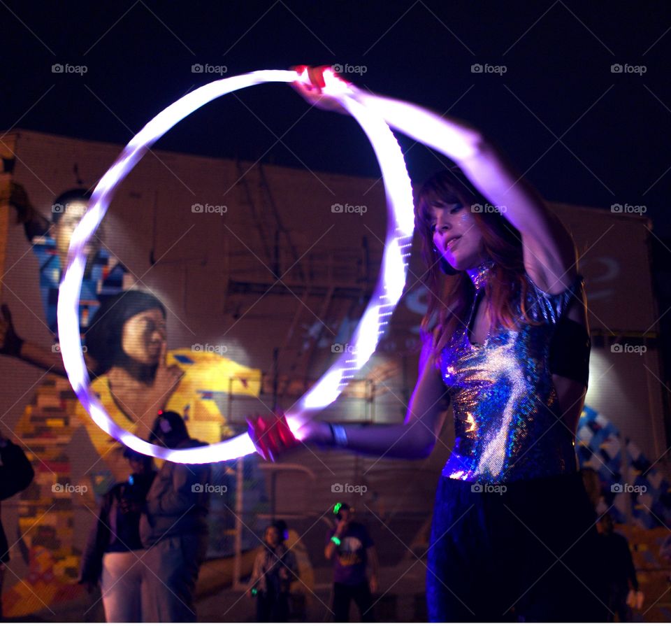 Glow Circle. Performer hulks with a neon circle at an art festival in the city. 