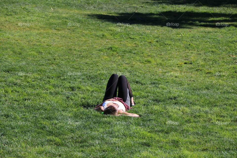 Laying down on a green grass and meditating- after a stressful day