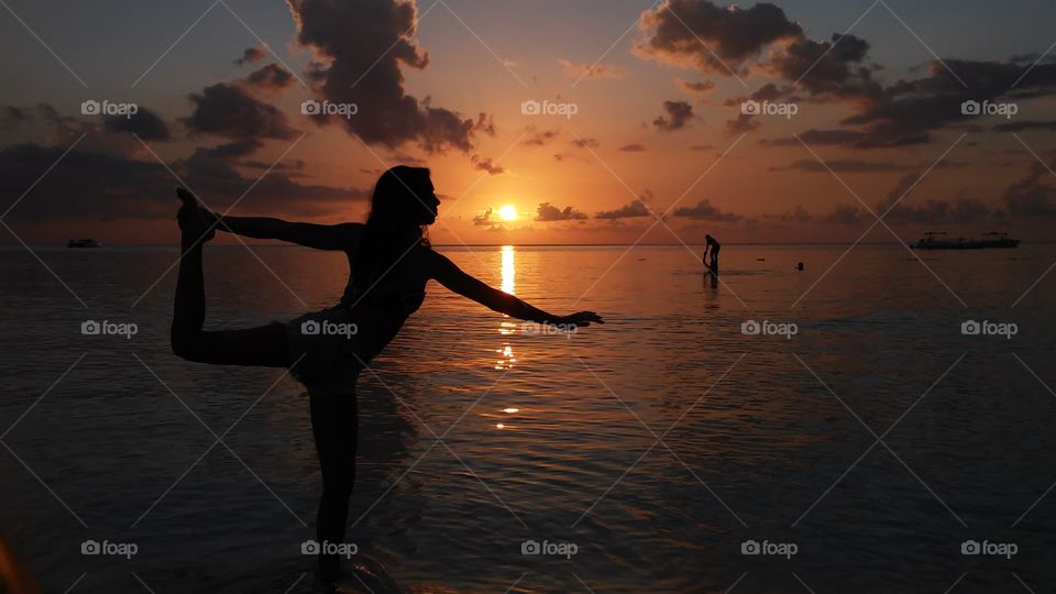 Silhouette of woman posing in front of the sun on jamaica beach