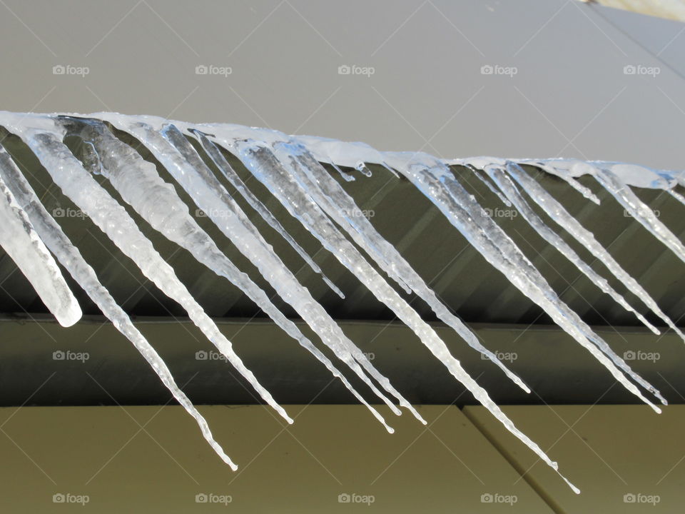ice icicles on the cornice in the sun, harbingers of spring