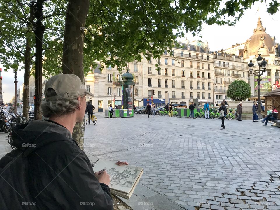 Discovering Paris. A street artist sketching historical buildings 