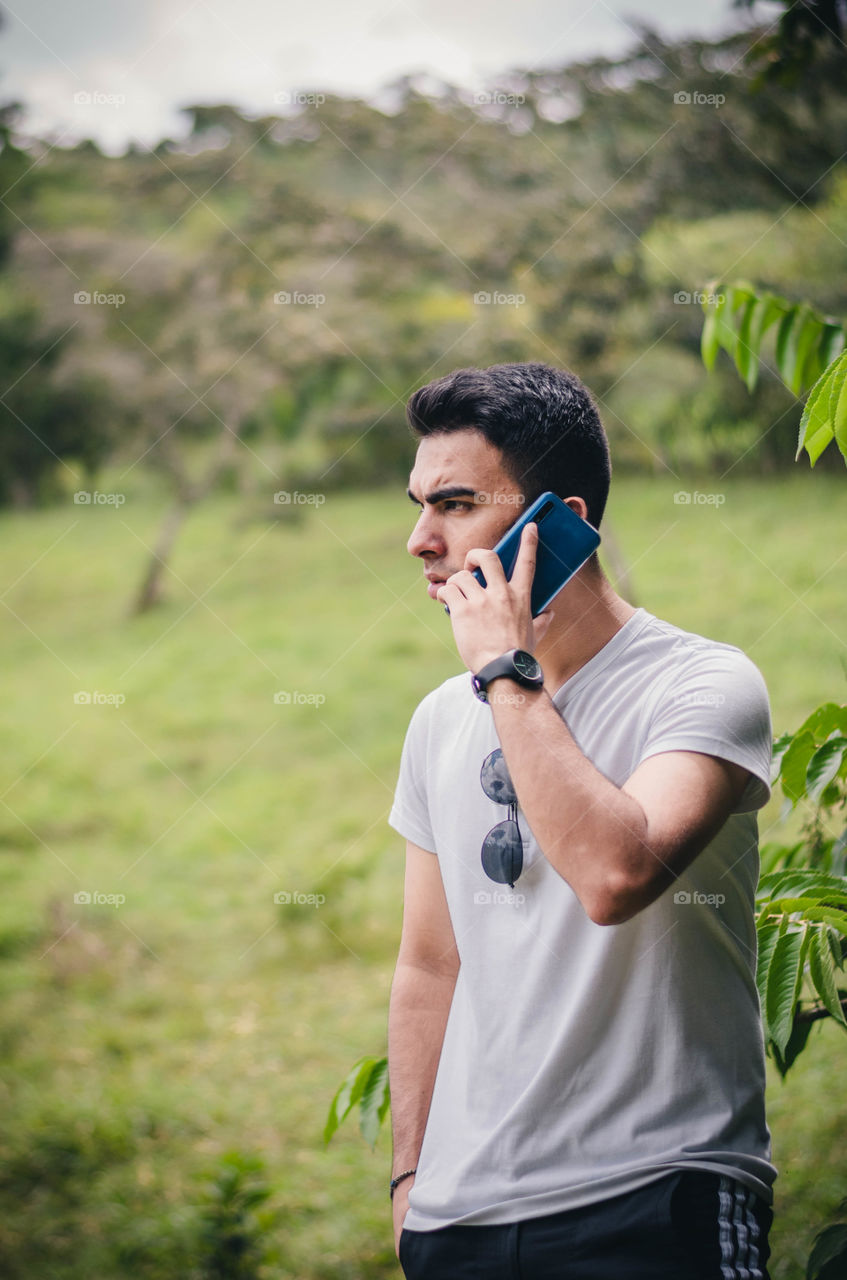 Young man using his favorite gadget.  Man calling on the phone