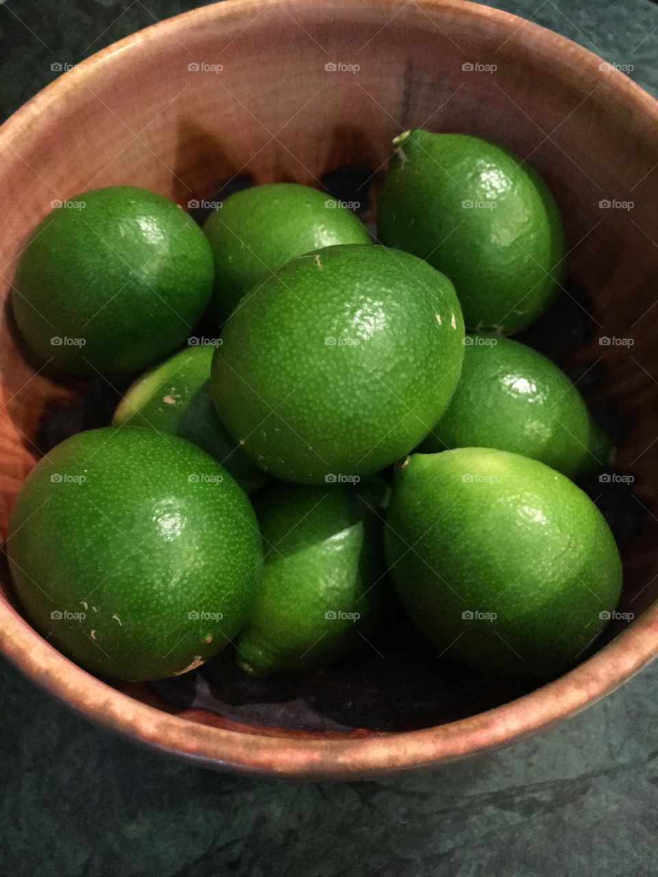 Keylimes in a brown pottery bowl