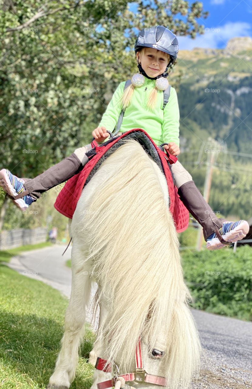 cheerful girl on a white pony