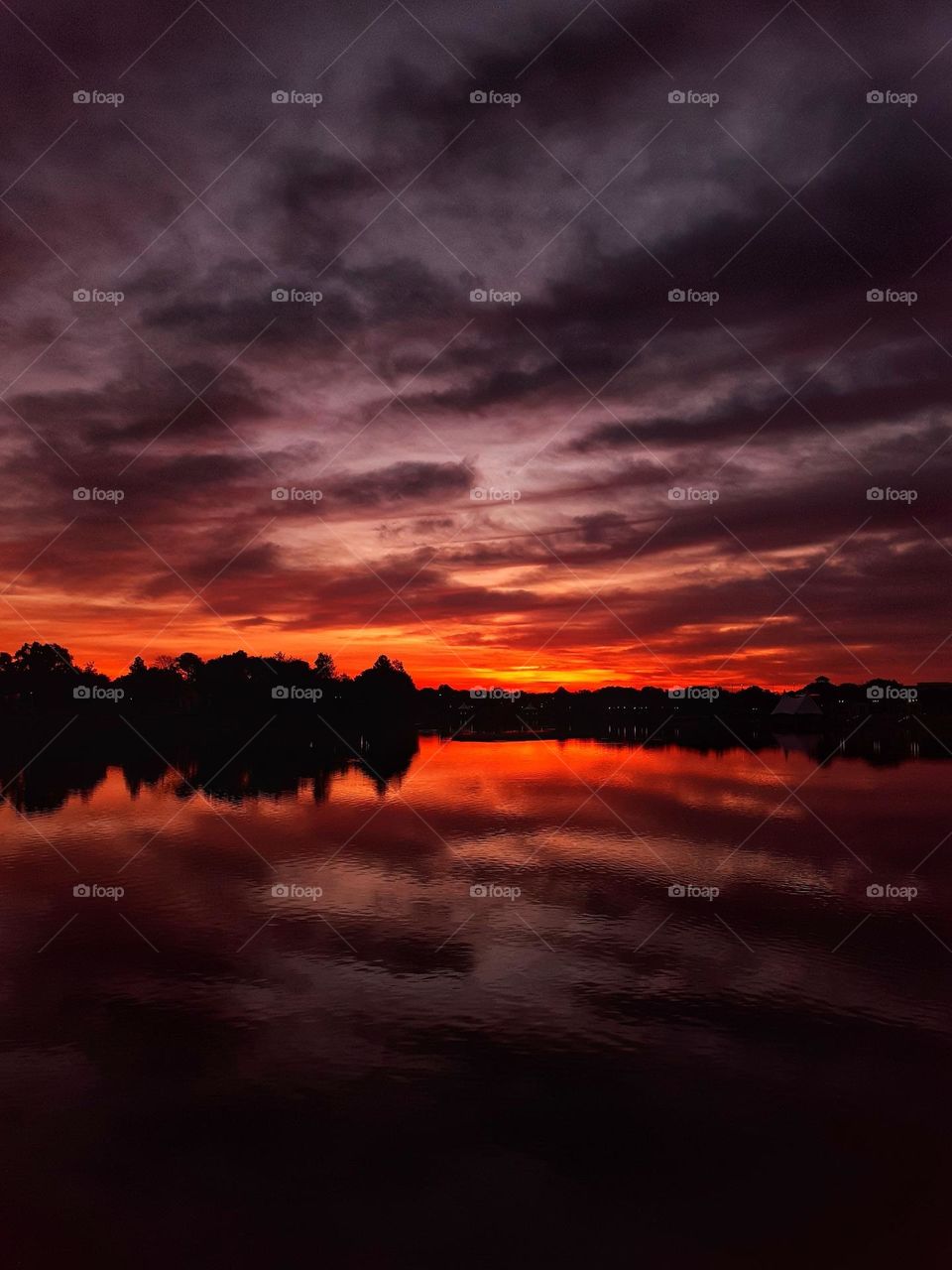 A beautiful reddish sunrise over the lake at Cranes Roost Park in Altamonte Springs, Florida.