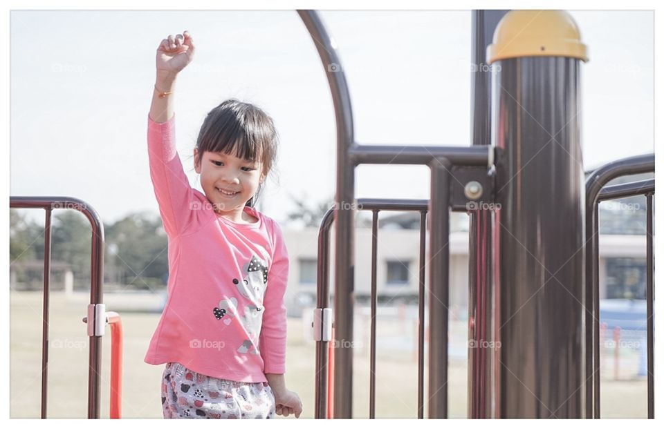 Triumph girl on top of playground 