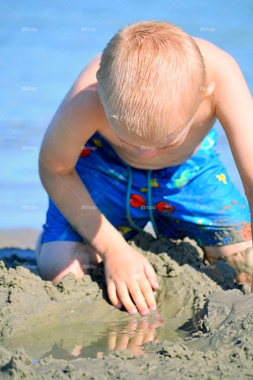 Boy digging in the sand