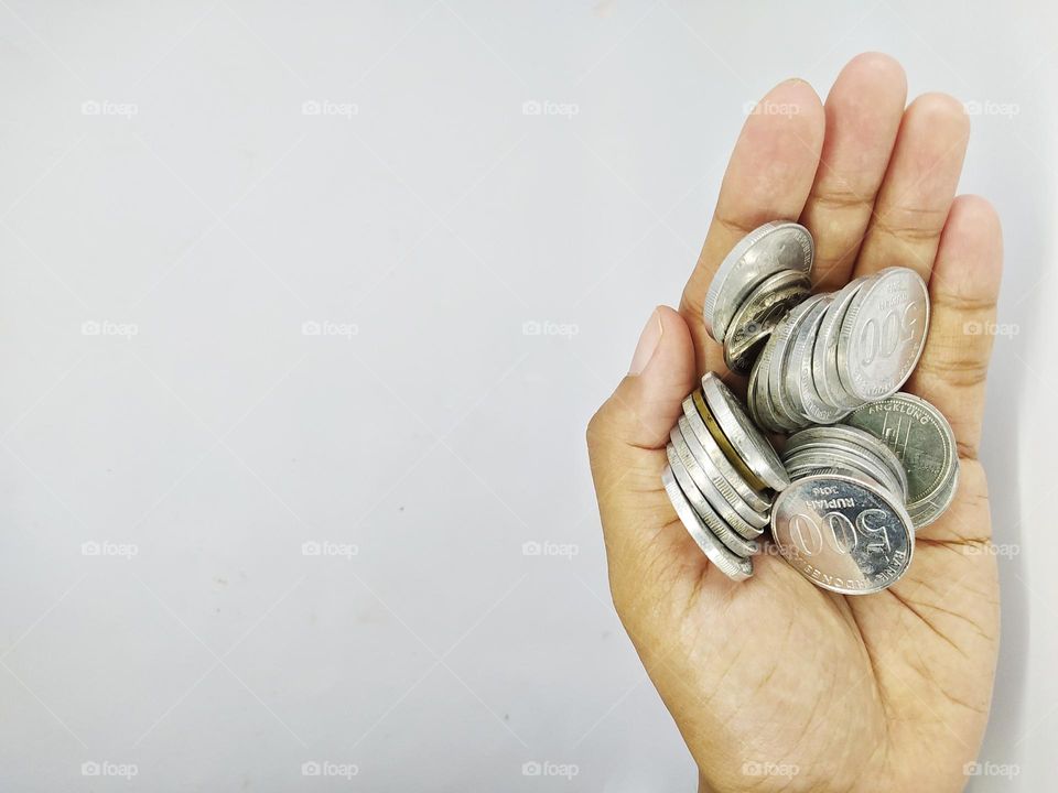 Holding some Indonesian rupiah coins, isolated on white background