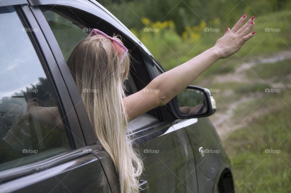 A girl rides in a car on the road