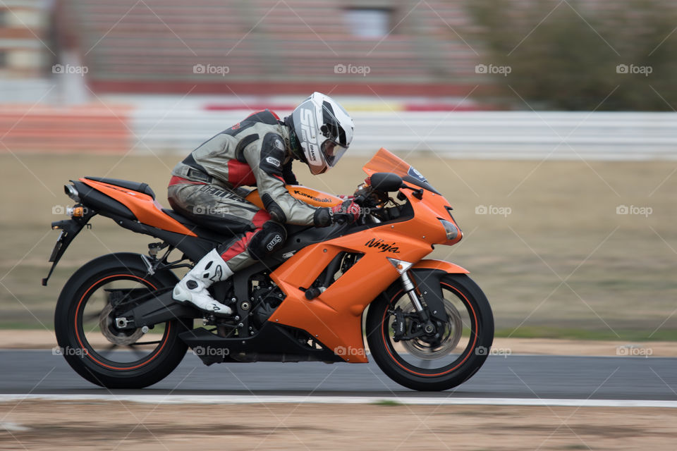 Orange sportbike and rider on circuit