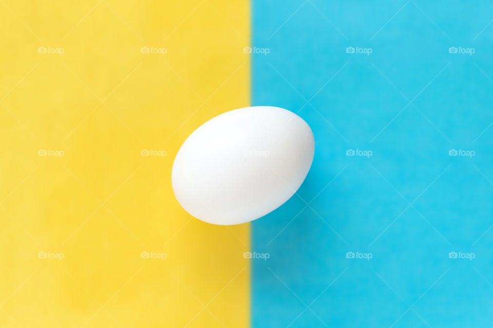 White egg on contrasty two colored background