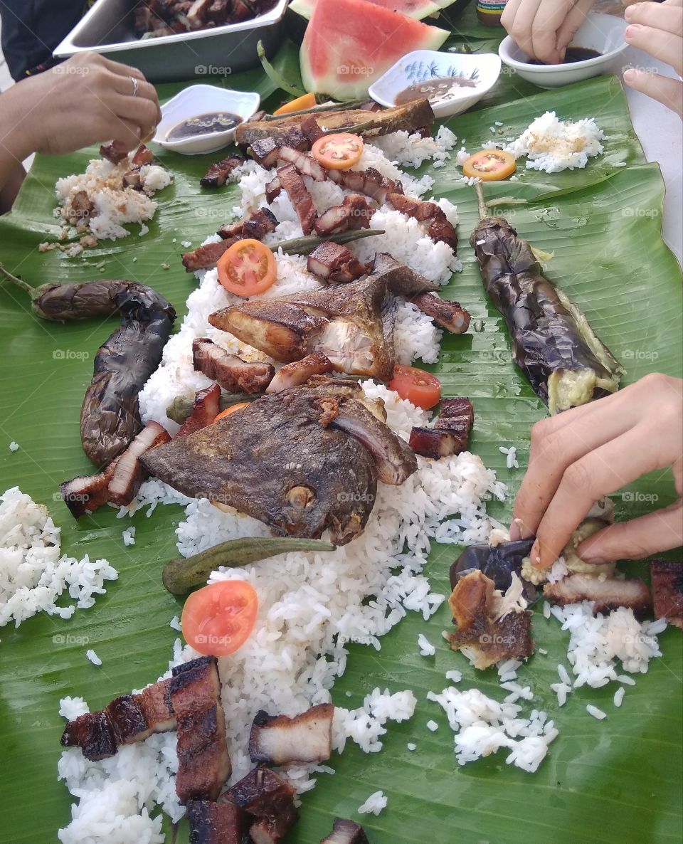 boodle fight eat with hands on banana leaf plate