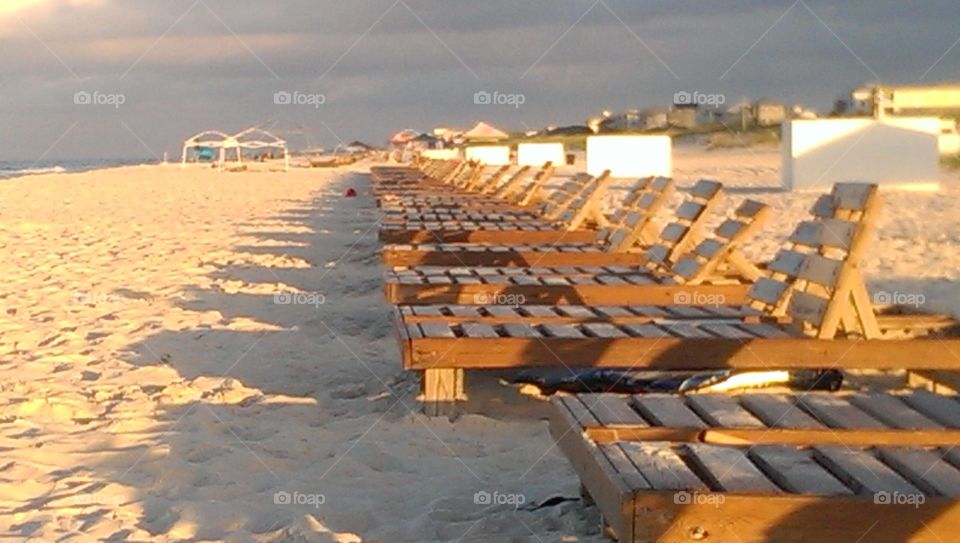 Early morning at the beach with rows of wooden beach chairs