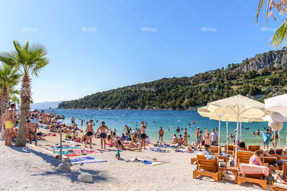Crowds of people on Kašjuni beach near Split, Croatia