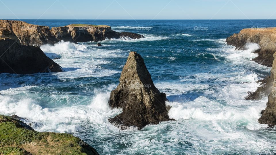 Wave splashing a rocky coastline