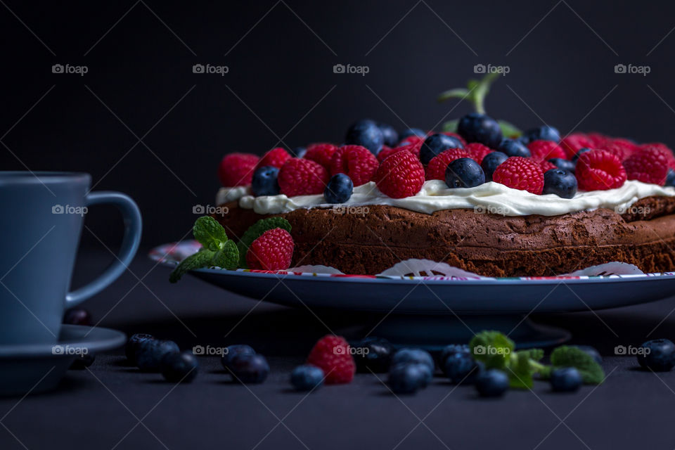 Close-up of cake with coffee cup against black background